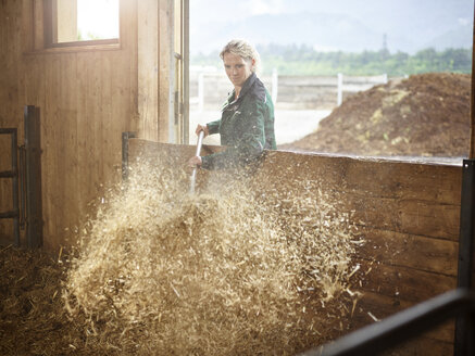 Female farmer working with straw on a farm - CVF00251