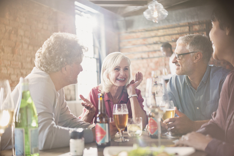 Paare, die sich am Restauranttisch unterhalten und Bier trinken, lizenzfreies Stockfoto