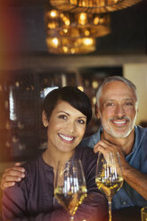 Portrait lächelndes Paar trinkt Weißwein in einer Bar - HOXF00015
