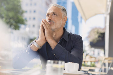 Pensive man drinking coffee at urban sidewalk cafe - HOXF00022