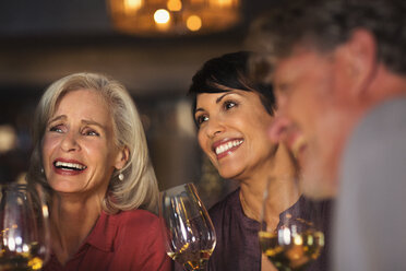 Lächelnde Frauen trinken Weißwein an einer Bar - HOXF00023