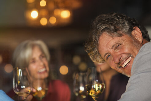 Portrait lachender älterer Mann trinkt Weißwein mit Freunden an der Bar - HOXF00029