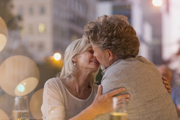 Zärtliches älteres Paar küsst sich in einem städtischen Straßencafé - HOXF00045