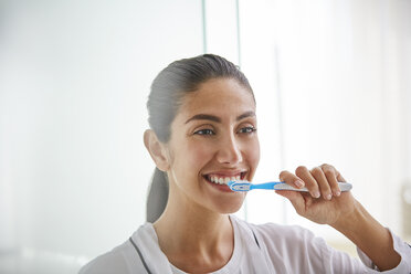 Woman brushing teeth with toothbrush - HOXF00052