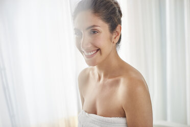 Smiling woman wrapped in towel - HOXF00056