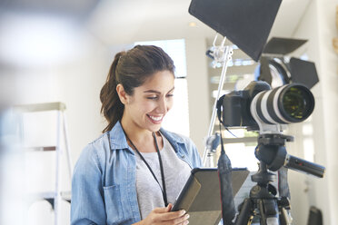 Fotografin verwendet digitales Tablet hinter der Kamera im Studio - HOXF00086