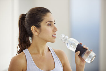 Frau trinkt Wasser nach dem Training - HOXF00099