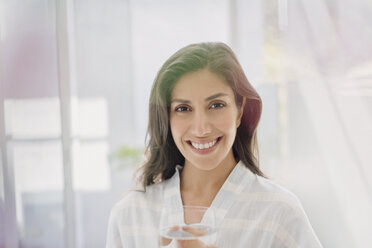 Portrait smiling brunette woman drinking water - HOXF00143