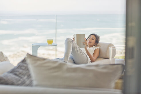 Frau entspannt Lesung Buch auf Chaiselongue auf Luxus-Balkon mit Meerblick - HOXF00154