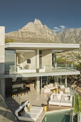 Sunny modern luxury home showcase exterior below mountains - HOXF00177