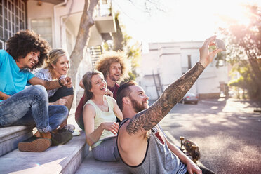 Freunde hängen ab und machen ein Selfie mit einem Fotohandy auf einer Treppe - CAIF04195