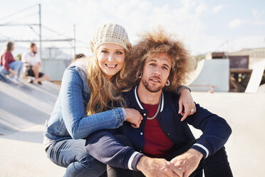 Portrait lächelndes Paar im sonnigen Skatepark - CAIF04219