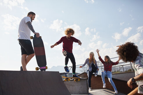 Freunde beim Skateboardfahren im sonnigen Skatepark - CAIF04221