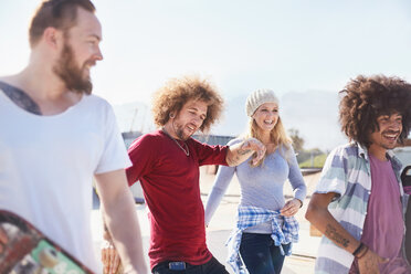 Lächelnde Freunde hängen im sonnigen Skatepark ab - CAIF04222