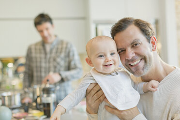 Portrait smiling gay father holding cute baby son - CAIF04284