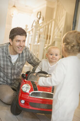 Vater und kleine Söhne spielen mit Spielzeugauto - CAIF04319