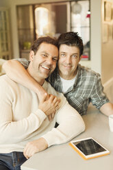 Porträt lächelnd, liebevoll männlichen Homosexuell Paar mit digitalen Tablet umarmen - CAIF04340