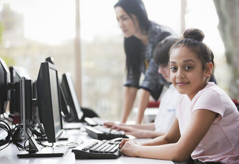 Porträt einer selbstbewussten Studentin am Computer in der Bibliothek - CAIF04362