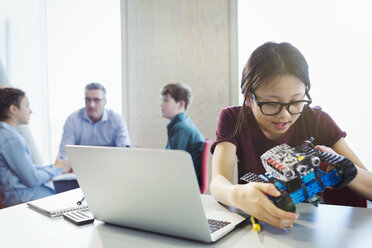 Girl student programming and assembling robotics in classroom - CAIF04364