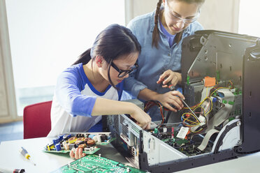 Girl students assembling computer in classroom - CAIF04365
