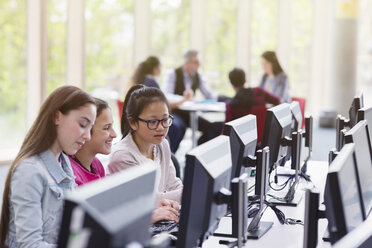 Girl students studying at computer in library - CAIF04370