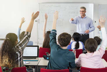 Männlicher Lehrer, der die Schüler im Klassenzimmer anspricht - CAIF04373