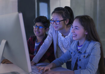 Schüler recherchieren am Computer in einem dunklen Klassenzimmer - CAIF04374