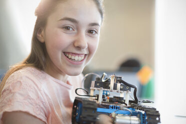 Portrait smiling, confident girl student holding robot - CAIF04375