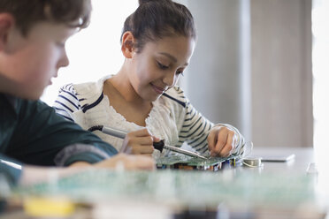 Schüler löten eine Leiterplatte im Klassenzimmer - CAIF04379