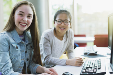 Portrait lächelnd, zuversichtlich Mädchen Studenten Forschung am Computer in der Bibliothek - CAIF04397