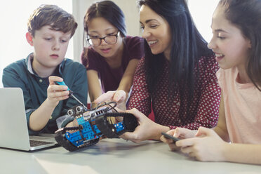 Lehrerin und Schüler beim Programmieren und Zusammenbauen von Robotern im Klassenzimmer - CAIF04410