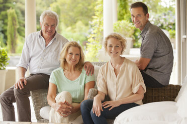 Portrait of smiling couples on patio - CAIF04434