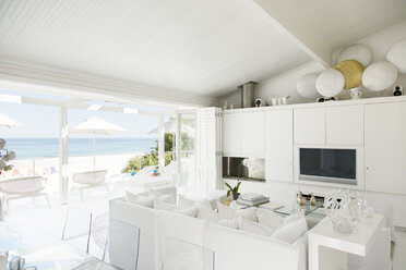 Modernes Wohnzimmer mit Blick auf Strand und Meer - CAIF04466