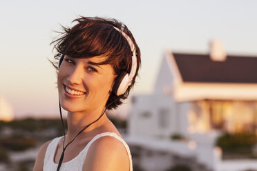 Portrait of smiling woman wearing headphones - CAIF04478