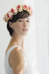 Portrait of serious bride wearing rose wreath on head - CAIF04487