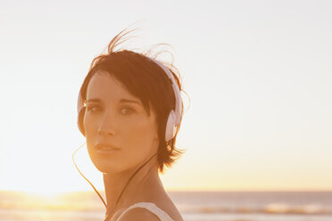 Close up portrait of confident woman wearing headphones at beach - CAIF04499