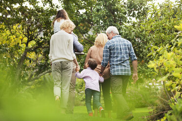 Mehrgenerationenfamilie beim Spaziergang im Park - CAIF04529