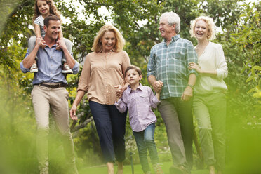 Mehrgenerationenfamilie beim Spaziergang im Park - CAIF04531