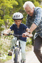 Großvater bringt seinem Enkel das Fahrradfahren bei - CAIF04538