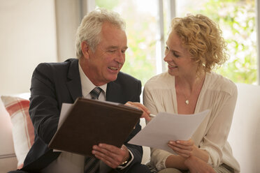 Financial advisor explaining paperwork to woman - CAIF04553