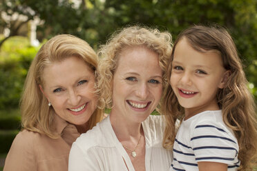 Three generations of women smiling outdoors - CAIF04563