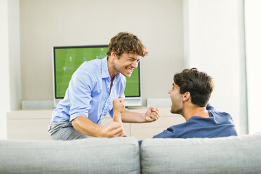 Men cheering and watching soccer game - CAIF04572