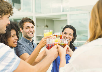 Friends toasting cocktails on patio - CAIF04592