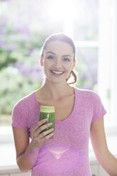 Portrait smiling woman drinking green smoothie - HOXF00193