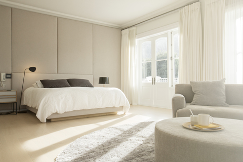 Sonniges Schlafzimmer mit Sitzecke, lizenzfreies Stockfoto
