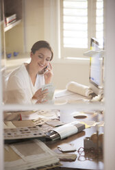 Innenarchitektin prüft Muster und telefoniert in ihrem Büro zu Hause - HOXF00203
