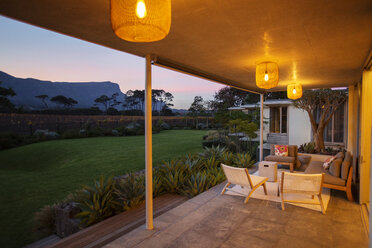 Illuminated patio overlooking mountains at dusk - HOXF00232