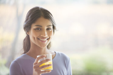 Portrait smiling woman drinking orange juice - HOXF00304