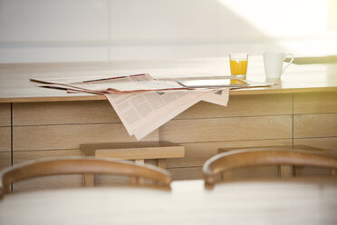 Newspaper, orange juice and coffee on kitchen island - HOXF00313