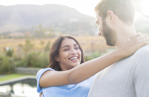 Enthusiastisches Paar umarmt sich im Freien, lizenzfreies Stockfoto